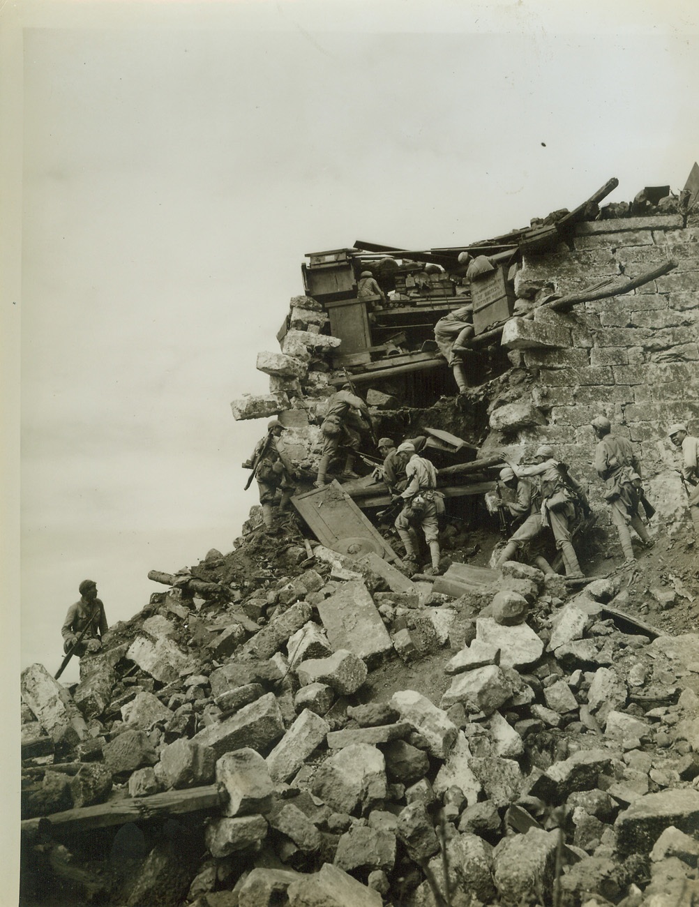 Tengchung Captured From Japs, 10/4/1944. CHINA -- The first city east of Burma to be liberated by the Allies, the ancient jade center of Tengchung has been captured from the Japs after five bloody weeks of fighting. Here, Chinese soldiers scale the blasted wall of the city. Smoke in the background is from Allied grenades that had been tossed over the wall.;