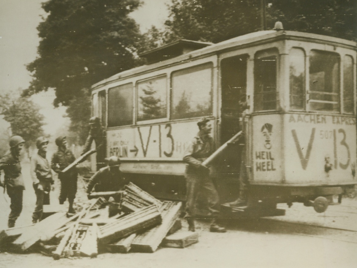 Street Car of Dynamite Headed for Aachen, 10/12/1944. GERMANY – American doughboys load up the V-13, a streetcar, with German ammunition before rolling it downhill where it exploded in the middle of the Nazi garrison at Aachen. this “secret weapon” has been used with notable effect in blasting the Nazis of Aachen from their dugouts. Photo by Acme photographer, Andrew Lopez, for the War Picture Pool.Credit (Acme Photo via Army Radiotelephoto);