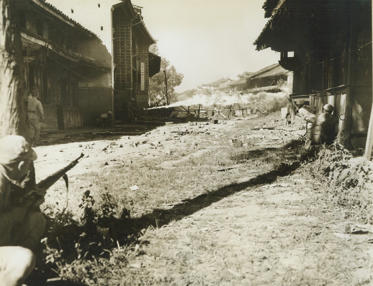 The Bloody Siege of Tengchung, 10/4/1944. Tengchung, China – Inching across the rugged, rain-soaked terrain of the Kaoli Mountains to face a heavily fortified Jap force at Tengchung, American-trained Chinese troops captured the ancient jade center after a bloody, five-week battle. The first Chinese city on the Eastern side of Burma to be liberated by the Allies, Tengchung was a battle-seared, rubble-strewn prize when the Chinese moved in. Approximately 2000 Japs, who were entrenched for a six-month siege, were killed or captured in the battle, which proved the Chinese Army’s ability to use modern weapons and tactics. The U.S. 10th and 14th Air Forces supported China’s fighters in the fight for the principal enemy obstacle to the junction of the Ledo and Burma roads. A Chinese flamethrower sends a searing stream of destruction toward a Jap pillbox in the fight for Tengchung. Photo by Frank Cancellare, ACME photographer for the War Picture Pool. Credit: ACME;