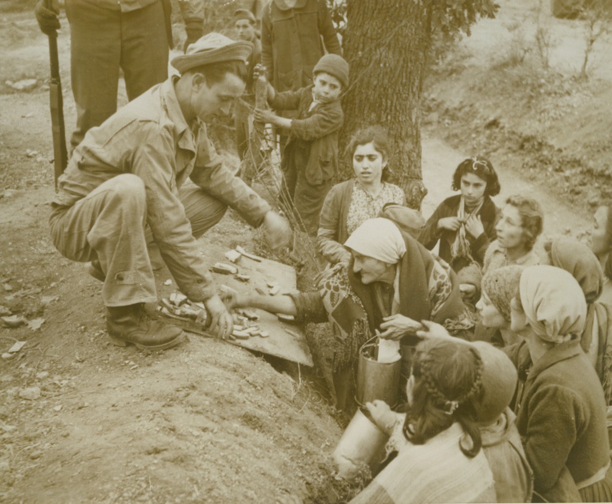 To Them It Means Nourishment, 2/2/1944. ITALY--Some of the starving destitute Italians who cluster around virtually every U.S. Army food dump in Italy scramble for their share of far over the barbed wire barrier scraping for her share, while others crowd close, their pails ready for leftovers, near the Cassino Front.Credit:  WP;