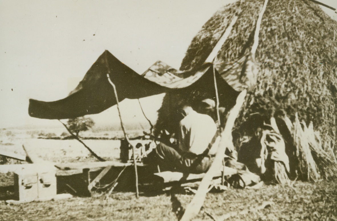 Field Communication, 2/9/1944. YUGOSLAVIA – Under a makeshift canopy at the side of a haystack, Partisan soldiers operate a field radio transmitter somewhere in Bosnia, where Partisan troops are tying up many German divisions. Credit Line (Acme);