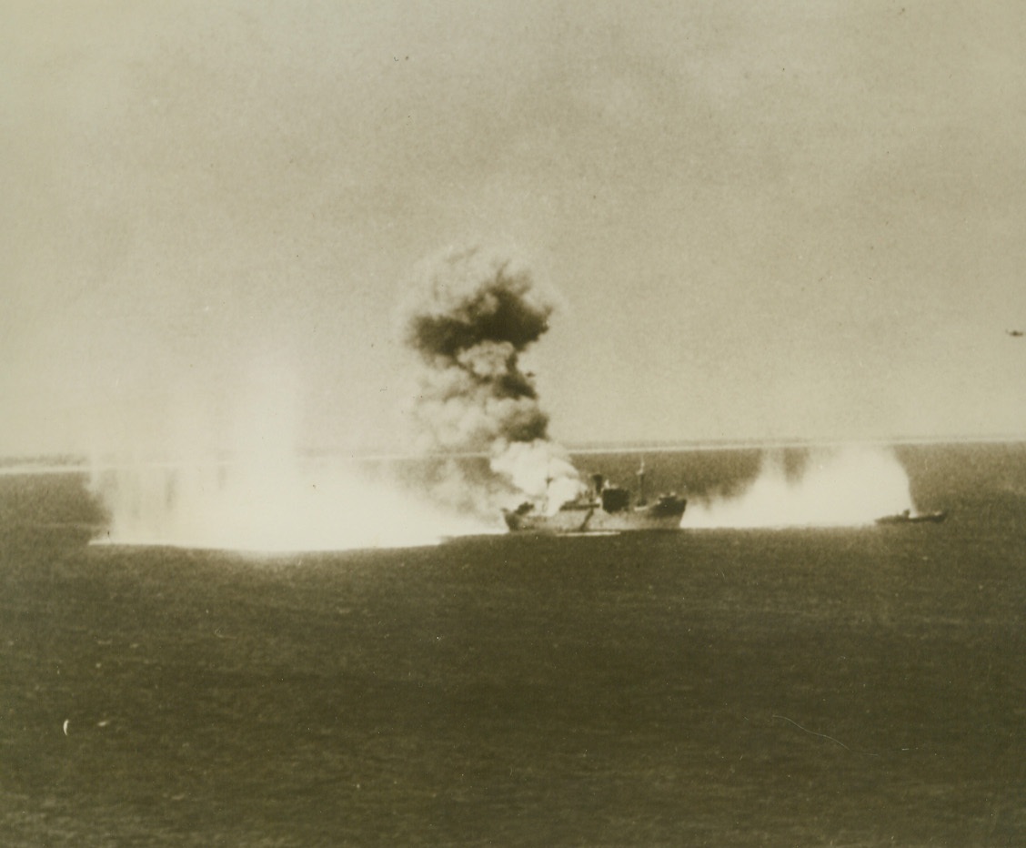 Japs Got a Taste of Things to Come, 2/15/1944. Marshall Islands – Low flying Navy bombers fire a Jap merchantman off Kwajalein Atoll, as part of the softening up exercises that preceded invasion by Marine and infantry forces.  Near-misses kick up a lot of water near the ship that suffered direct hits amidships.Credit (U.S. Navy official photo from ACME);