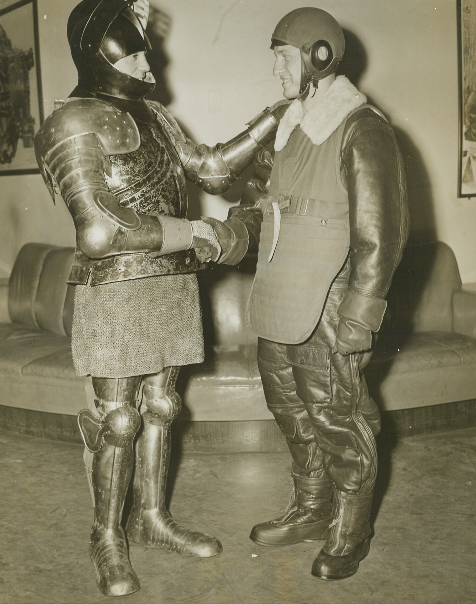 You’re Safe, Bud, 2/19/1944. New York City—Decked out in the cumbersome armor and mail used for protection by ancient warriors, Pfc. Kenneth Tracy tells Pvt. Lee Morris (right) that he’s twice as safe and many times more comfortable in the Army Air Forces body armor the modern flier wears. Designed to protect airmen from enemy flak, the new body armor is shown publicly for the first time at the Army Ordinance Exhibit in the Chrysler Building.Credit: ACME.;