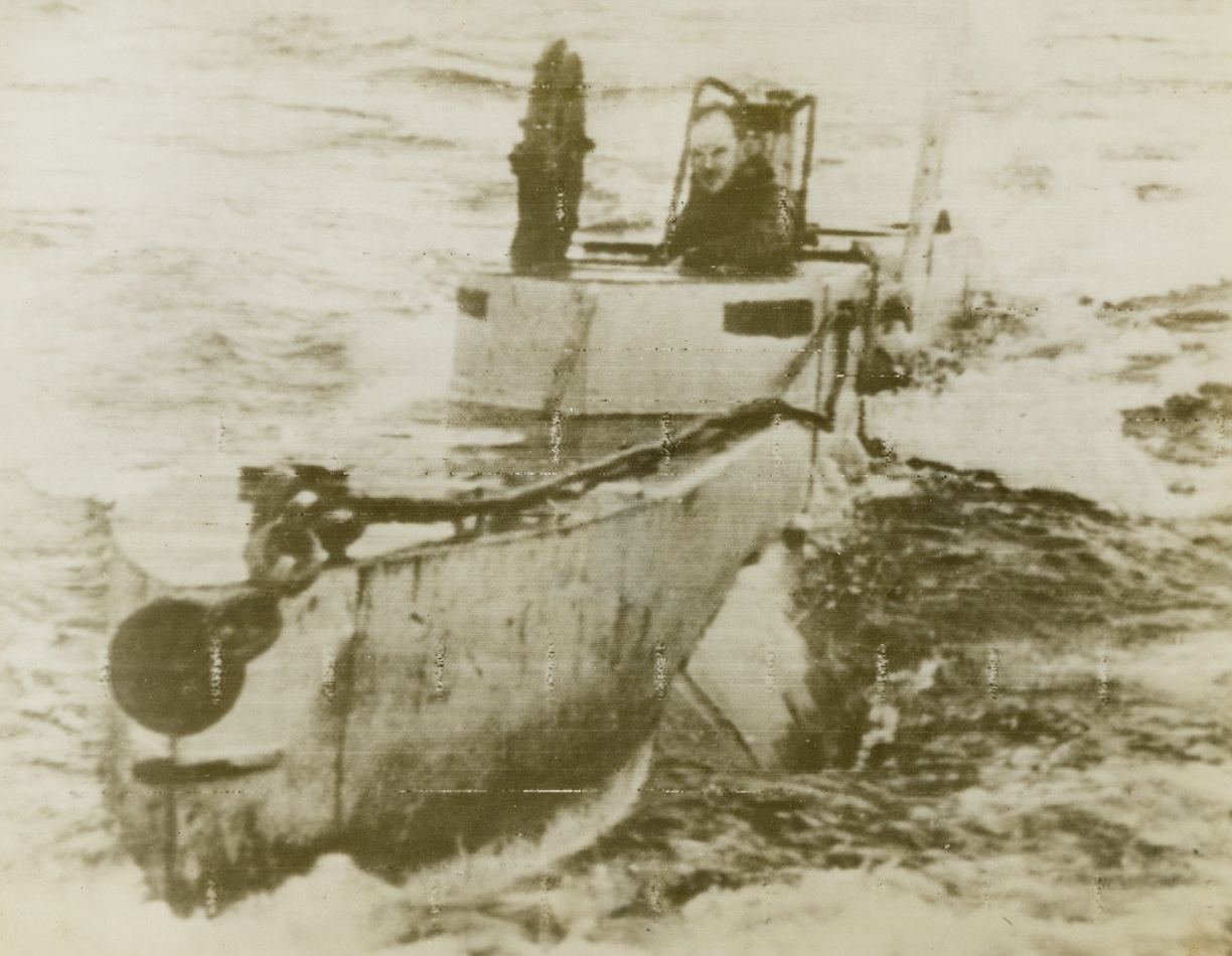 Britain’s Midget Submarine, 2/22/1944. England - A crewman looks out of the conning tower of a tiny, British three-man submarine of the type that helped wound the mighty German warship Tirpitz last fall. Small and deadly, the sub can penetrate shallow channels, sneaking up into an enemy vessel’s hiding place. Credit: ACME Radiophoto;