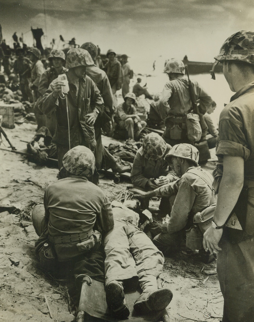 Blood Plasma Saves Eniwetok Hero, 3/23/1944. Eniwetok Atoll – American Marines give blood plasma to a wounded comrade after blasting their way ashore on Eniwetok Atoll.  Somewhere, back home in the U.S., someone was responsible for saving this Marine’s life with their donation to the Red Cross blood bank. Credit line (U.S. Coast Guard photo from ACME);