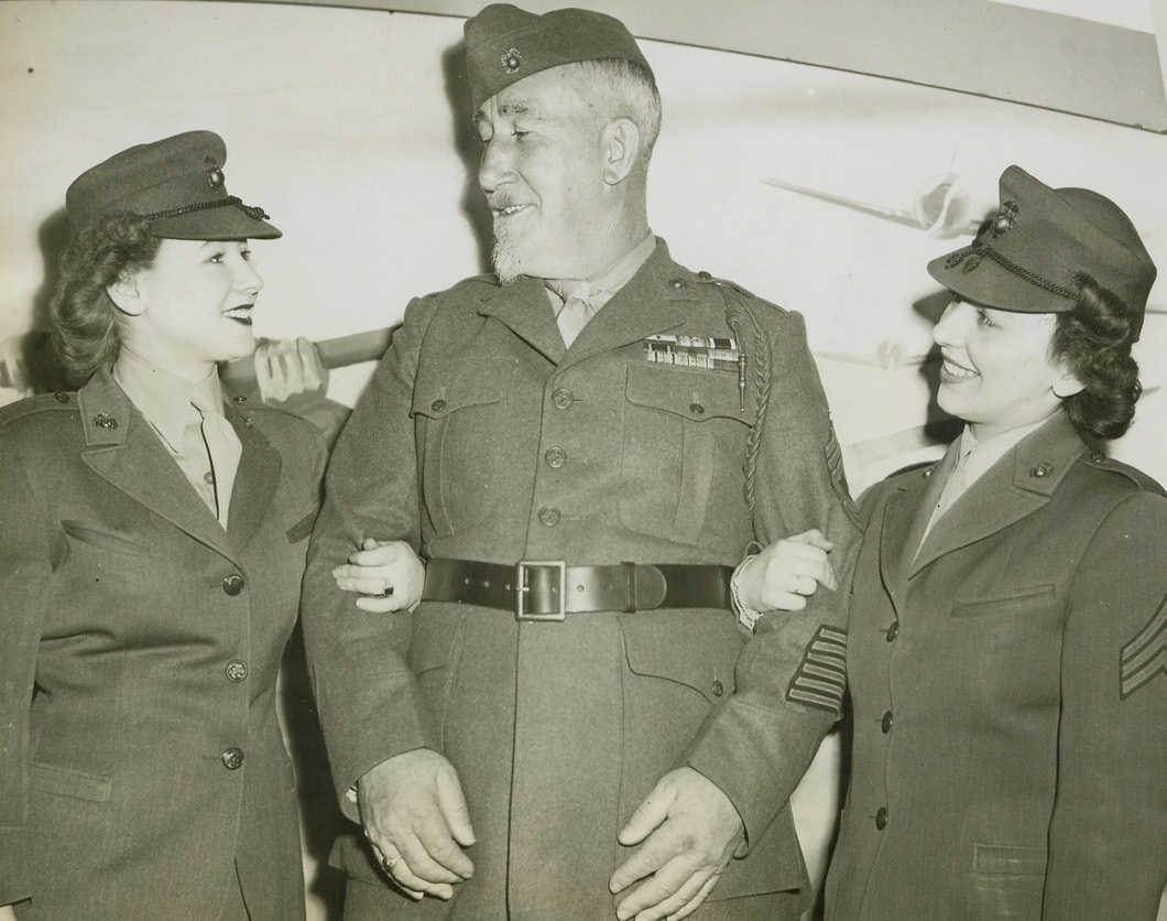 Marine Hero Returns, 3/29/1944. Chicago -- Veteran Marine gunner Sgt. Lou Diamond has proved the enemy can’t distract him, but it’s a different story when he meets pretty lady leathernecks Sgt. Betty Fitzgerald (left) and Sgt. Lorraine Ptacek while visiting Chicago. Sgt. Diamond earned his place among Marine legendary characters when he lobbed a shell down the chimney of an abandoned farmhouse during World War I. In World War II, he won a citation for accurate mortar fire after landing with the first waves at Guadalcanal and Tulagi. Only when a minor ailment sent him to the hospital did an amazed doctor discover he was 53 years old. Now Diamond is en route to Parris Island, South Carolina, to be an artillery instructor. Credit: ACME;