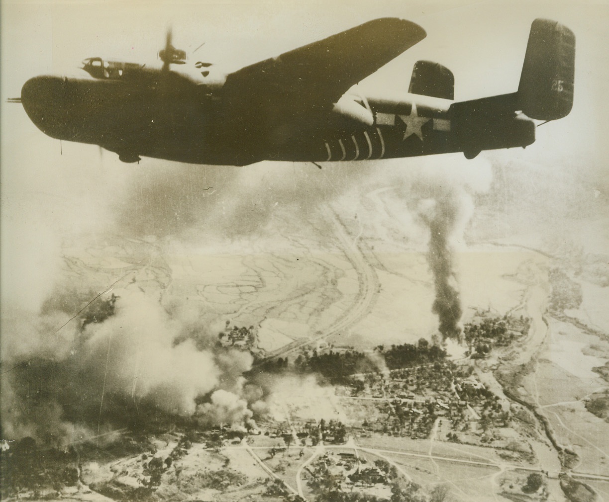 Bombs Away – Over Romania, 4/29/1944. Romania has felt the weight of our air might before. This picture was taken during a recent raid by the 15th Army Air Force on the marshalling yards at Ploesti. A B-24 Liberator is seen dropping its load of eggs on it’s target. Ten bombs may be seen descending.  Credit: Army Radio telephoto from ACME;