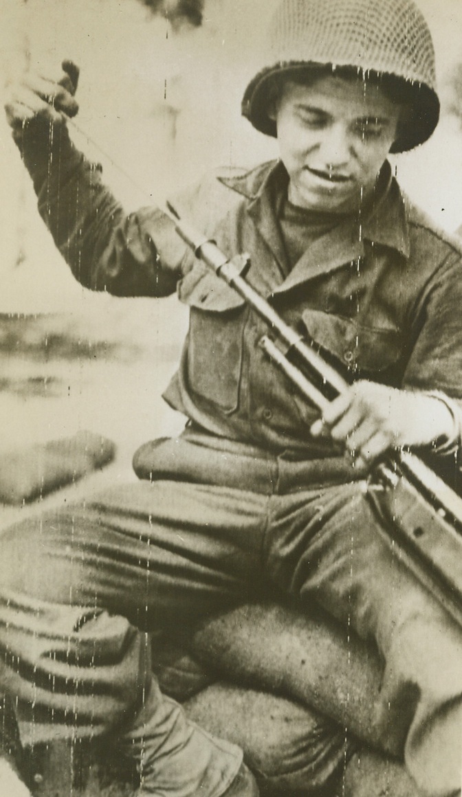 HIS RIFLE “HAS 40 NOTCHES”, 4/19/1944. NETTUNO, ITALY—Pvt. Alton W. Knappenberger, 20, of Spring Mount Pa., cleans the automatic rifle with which he recently killed about 40 Germans during a hour and a half “blitz” on the Nettuno Beachhead Front. During the skirmish, he fired 600 rounds of ammunition killing a German officer and seven men who ordered him to surrender, and played havoc with other Nazis in the vicinity. He is the latest to be given the term, “One Man Army.”Credit: U.S. Signal Corps Radiotelephoto from Acme;