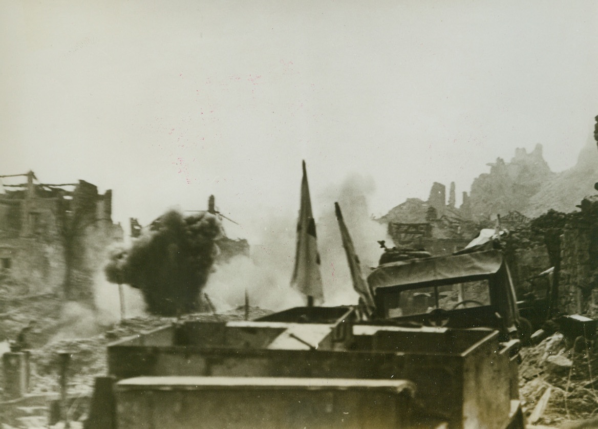 ACCIDENT AT THE FRONT, 4/1/1944. CASSINO, ITALY—At a corner of the road leading to Cassino from the north, a jeep and an ambulance, both riddled with shrapnel, are “piled up”. Enemy shells burst amid the wreckage all around the crashed vehicles. Reports from Cassino indicate that the months-long stalemate on this front may be at an end, with the Allies smashing forward in a three-pronged drive designed to outflank German troops at Cassino. Credit: Acme;