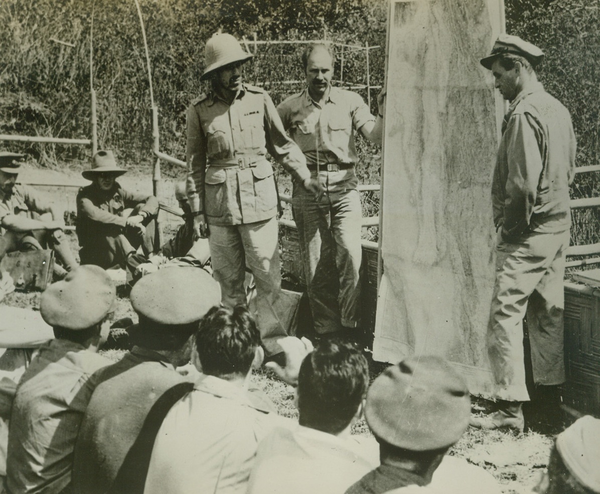 Air Commandos Outwit Japs, 4/20/1944. Burma – In a recent daring infiltration behind Jap lines in Burma, the 1st Air Commando Force, commanded by Col. Philip J. Cochran, (above, standing at right), of the U.S. Army Air Forces, landed men in gliders to construct an airfield, then transferred the troops of Maj. Gen. Orde C. Wingate’s British Command to the field in transport planes. The field, named “Broadway”, was some 200 miles east of Imphal, India, where the British and Japs are now locked in battle. Here, American and British officers are given their final briefing before taking off on the mission, by Gen. Wingate, (standing, left), and Col. Cochran. Wingate was killed in combat later. Credit: USAAF photo from ACME;