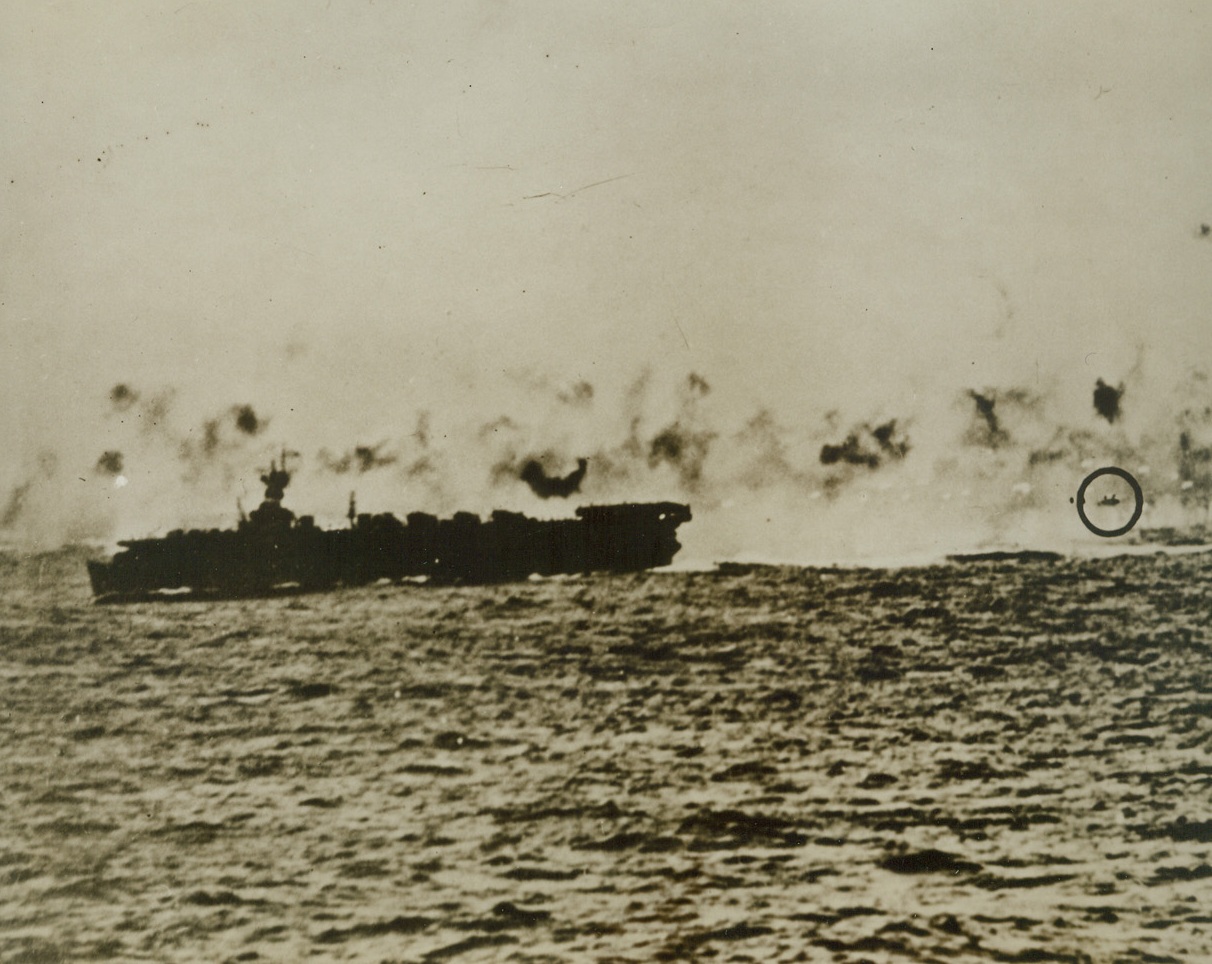 Death Claims Another Jap, 4/5/1944. Seconds after this photo was taken, the Jap “Betty” bomber marked by the circle (right), slammed into a deadly wall or anti-aircraft fire from the U.S. Navy carrier, left), and crashed into the sea.  The Nip plane was one of those trying futilely to ward off the attack of a U.S. Navy task force of Saipan, in the Marianas last Feb 22nd. Credit line (U.S. Navy official photo from ACME);