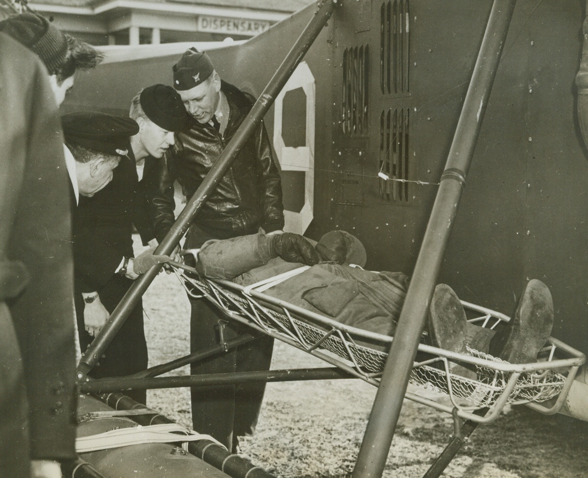 Helicopter to the Rescue #4, 4/16/1944. New York City—The Third Naval District’s air arm of the U.S. Coast Guard is now using helicopters for patrol and rescue assignments. While such uses are admittedly in experimental stages, Coast Guardsmen have found that, particularly in the case of rescue work, the little plane is speedier and eliminates much of the rough handling unavoidable in other methods of rescue. In a recent demonstration, the helicopter (above) has landed right at the door of the dispensary and waiting pharmacist’s mates can remove “wounded” flier directly into a ward without transferring him to an ambulance.Credit: Coast Guard photo from ACME.;