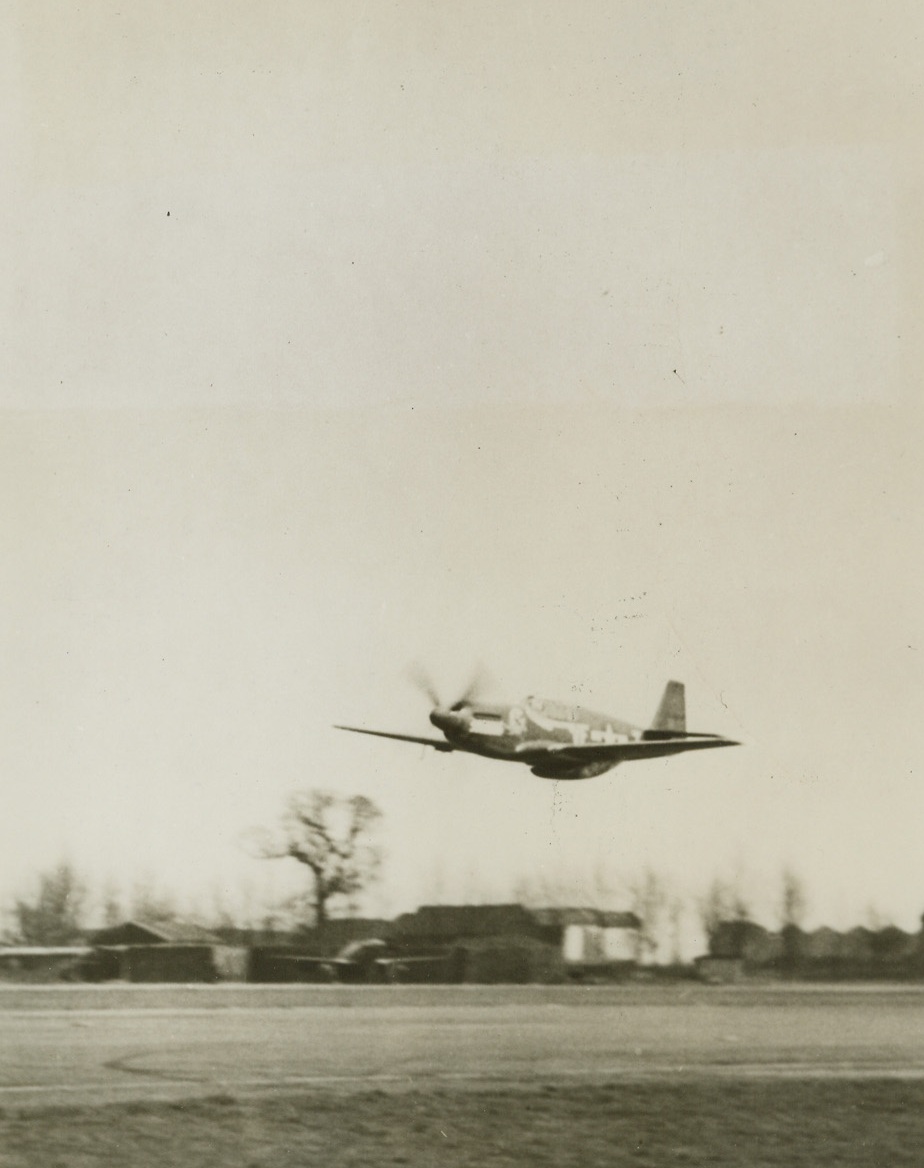 AMERICA’S 30-PLANE ACE IN ACTION, 4/12/1944. ENGLAND – Capt. Don S. Gentile of Piqua, Ohio, is the first American Ace of World War Two formally recognized as having broken Capt. Eddie Rickenbacker’s record in the last war of 26 planes, and yesterday, Gentile was decorated with the Distinguished Service Cross by Gen. Dwight D. Eisenhower.  Last Saturday, Capt. Gentile downed three German planes when he led a P-51B mustang fighter group escorting U.S. Liberators on a mission over Northern Germany.  At the same time, he received official confirmation for destroying five planes on the ground, bringing his current total to 30 – seven destroyed on the ground and 23 in the air.  One of the few original members of the RAF Eagle Squadron still flying, Capt. Gentile transferred to the U.S. Army Air Forces in 1942.  He now flies his mustang from a base in England, where he is shown (photo above).New York BureauWith the wheels of his mustang up, Capt. Gentile pulls the ship into a climb after taking off from his base.Credit: Acme;