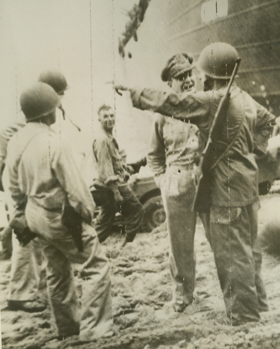 "Over There, General", 4/26/1944. An American officer points out on the water to illustrate a point in his animated discussion with Gen. Douglas MacArthur, (wearing cap), on the beach at Tadji, in the Hollandia area of New Guinea, after the General had supervised landing of Allied troops at this point, 1,800 yards from the Tadji Airfield, last April, 22. Soldier in center background, seems to be enjoying the talk. At the right, (background) is an LST. 4/26/44 (Acme Photo Via Army Telephoto);