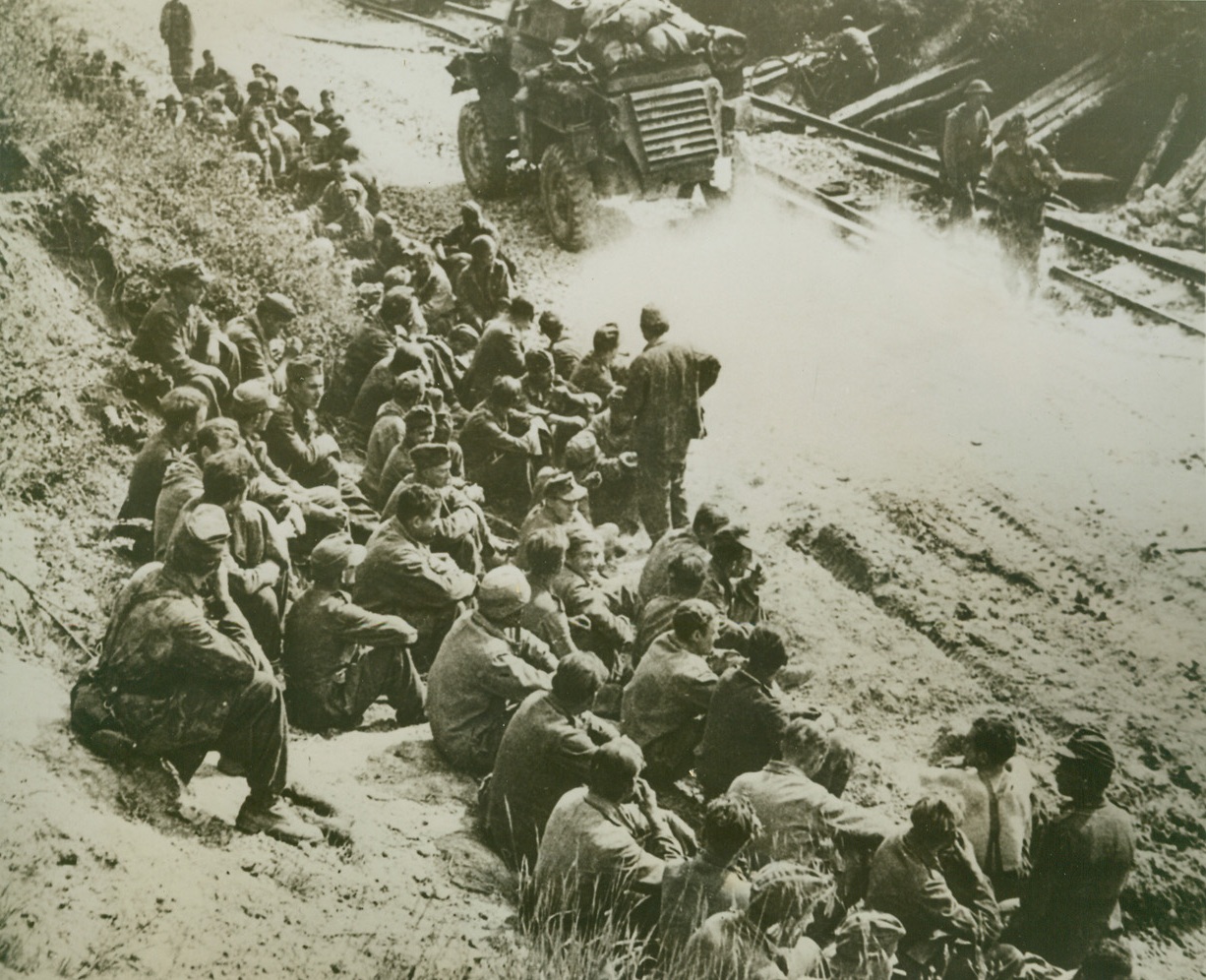 Nazis Get Time Out, 5/25/1944. ITALY – Unlike the infamous “March of Death” American soldiers captured in the Philippines were subjected to, these Nazi prisoners of war get a chance to rest along an Italian road as they are herded to the rear lines and PW compounds.  Allied armored vehicles pass the Nazis on their way to reinforce the frontline troops.  Thes prisoners are some of the huge haul taken in the early stages of the drive against the Gustav Line by the Allied Fifth and Eighth Armies.Credit-WP-(ACME);