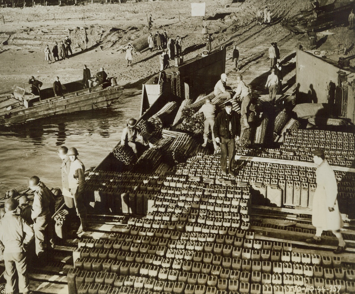 Specialists to Play Important Part in Invasion, 5/3/1944. On invasion maneuvers United States Army specialists use the versatile “duck” to haul gasoline cans from the mother barge to the shore. One of the most complex military organizations known to exist, the specialist branch includes medical technicians, telephone operators, ordnance men, and other workers covering all phases of army life and military operation. With this variety of skilled men in their organization, it is expected that the specialists will play a prominent part in the coming invasion of Europe. Credit: US Army photo from ACME;