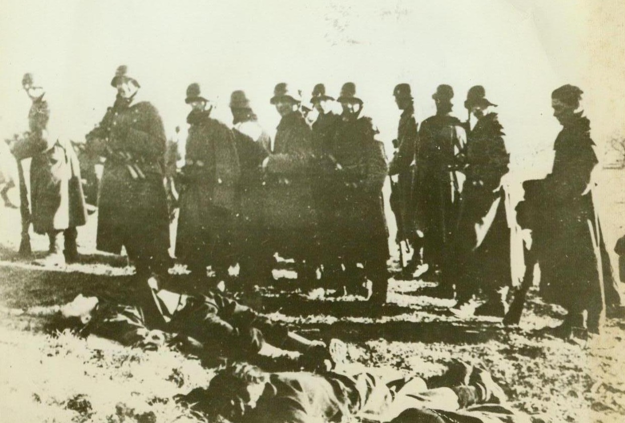 Murderers!, 5/18/1944. France - After executing a group of French patriots who were ordered to die because resistance in the area was becoming too much for the German High Command to handle, these German warriors take a last look at their victims before leaving the scene of mass murder. Only one (extreme right) of the group has the decency to bare his head in the presence of the dead, while the rest appear pleased with the job that will be avenged as efficiently as it was executed. Credit: ACME;