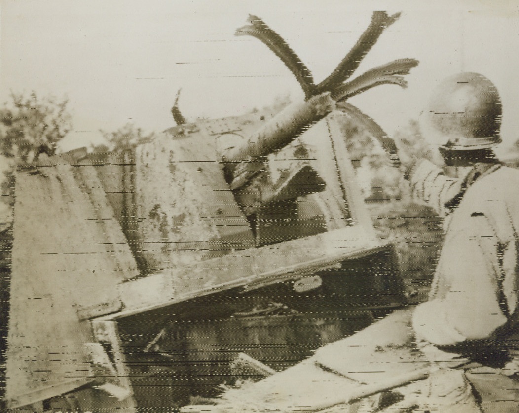 Knocked-Out Nazi Gun, 6/5/1944. ROME—Curiously, a Yank examines the shredded barrel of a large German gun, which was destroyed by fleeing Nazis on the outskirts of Rome so that the equipment would be useless to Allied troops who followed hot on their heels. The town steel through which Nazi shells once poured out at our fighters blew out in strips, making the gun’s nose look like a bedraggled palm tree.  Credit: U.S. SIGNAL CORPS RADIOTELEPHOTO-ACME.;