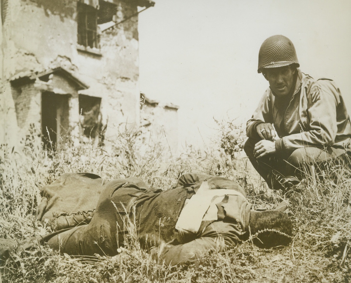 One Price for Rome’s Liberation, 6/14/1944. ITALY – The drive for the liberation of the Eternal City, which was accomplished June 4th, was costly to the Allies in men and material – but to the Nazis, it was the beginning of the end of their occupation of Italy, Now, they are fleeing to the north in disorderly retreat. Here, in a photo taken during the most violent part of the battle for Rome and released today in the U.S., a soldier of the U.S. Fifth Army, comforts a buddy badly wounded during the fighting in the Cisterna area.Credit Line (U.S. Signal Corps Photo from Acme);