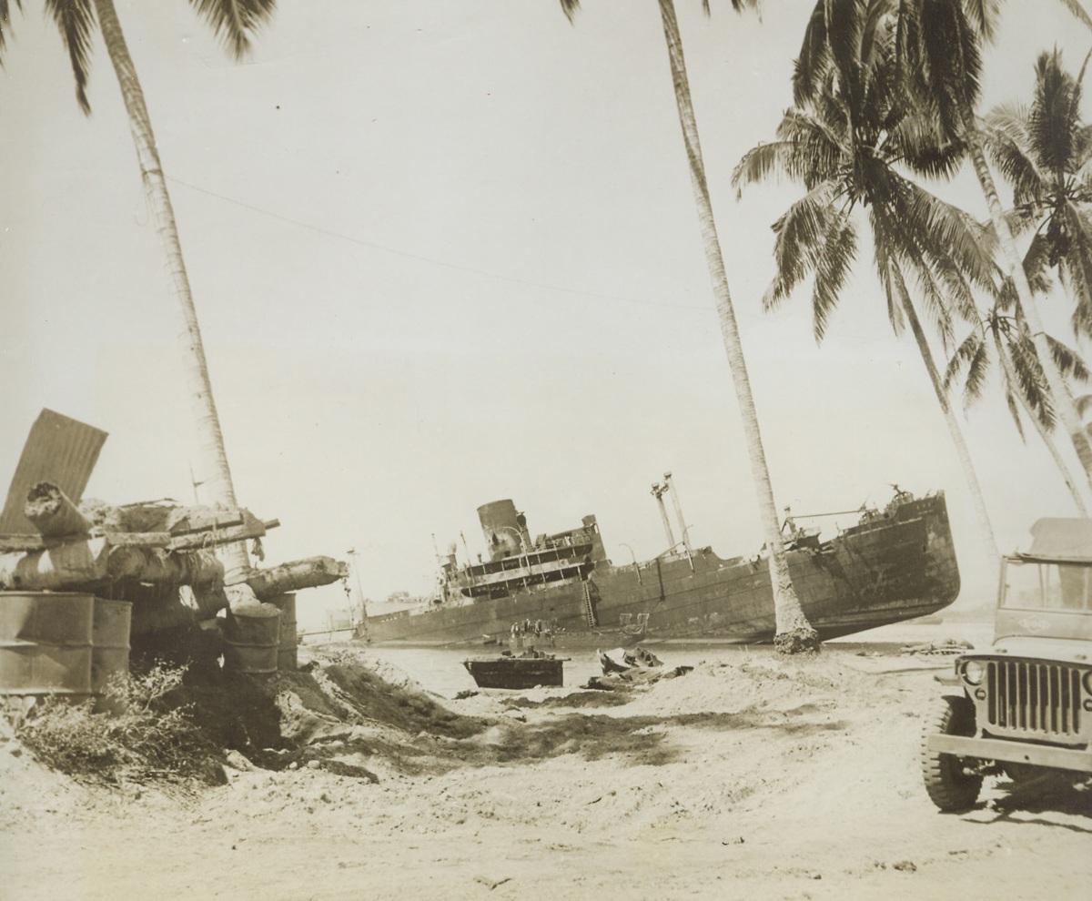 Skeleton, 6/14/1944.  New York City – The Kunigawa Maru, Japanese troopship, lies battered and beached on the shores of a South Pacific Island, a skeleton remnant of the one-mighty Japanese fleet. At left is a remains of a Jap pillbox. The Kunigawa Maru was beached during the battle of Iron Bottom Bay in the Coral Sea between Guadalcanal and Savo Islands. Credit: ACME;