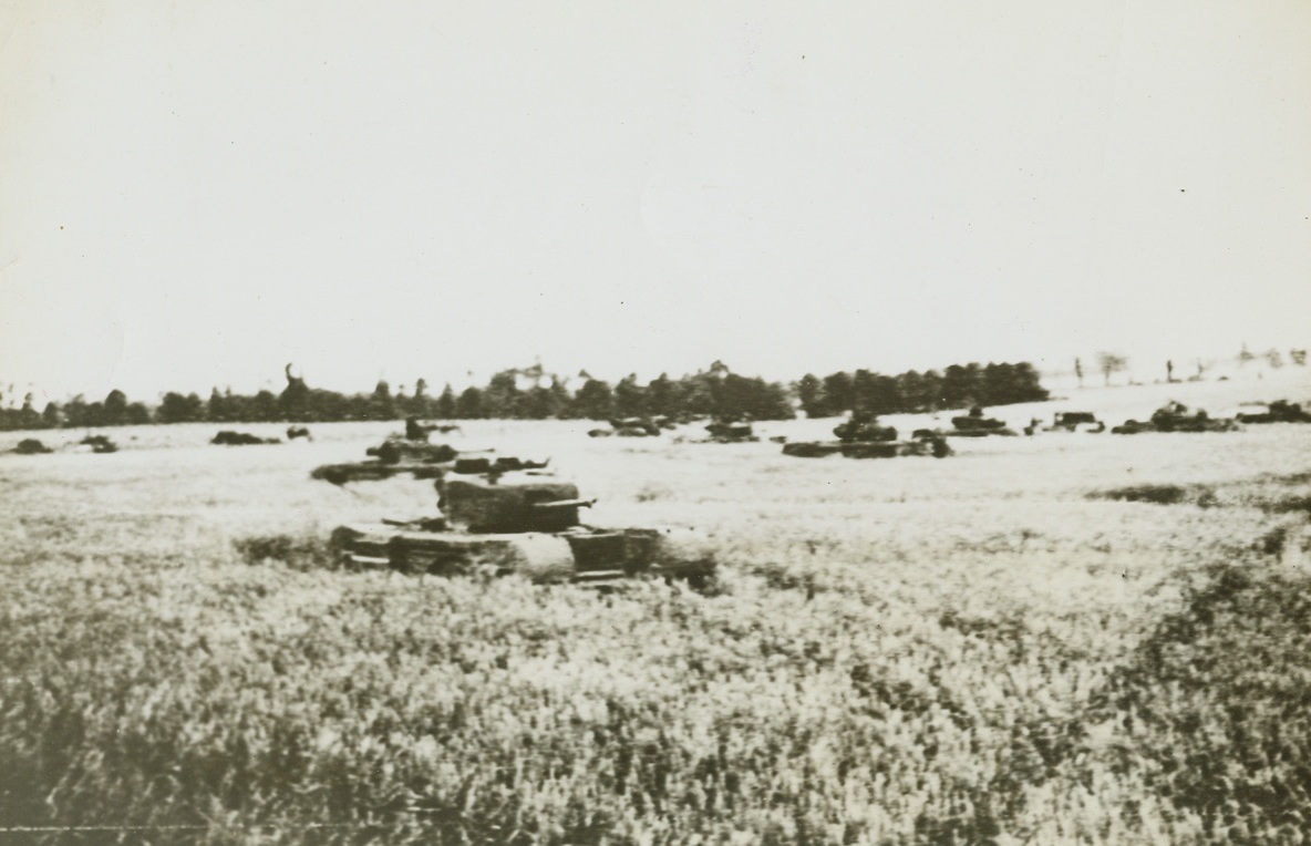 Tanks Charge to Battle, 6/30/1944. France—British tanks dash across a cornfield in France to engage German armored forces in what may amount to the decisive battle for the key city of Caen. German broadcasts have stated that the British drive represented “a gigantic attempt to cut off and capture Caen.”  Credit: British war office photo via Army radiotelephoto from ACME.;