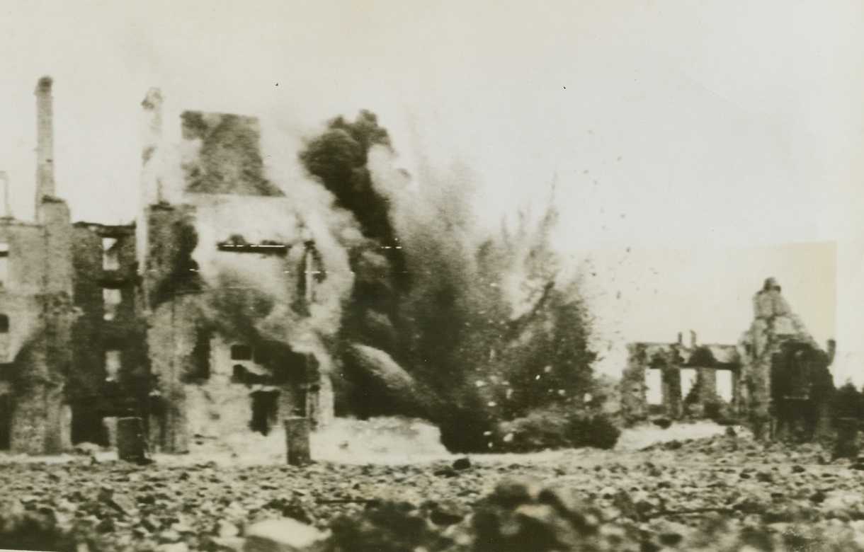 Getting Ready To Build Anew, 6/22/1944. Valognes, France -- Charges places by U.S. Army engineers topple damaged--and dangerous--buildings in Valognes after the city was taken from the fleeing Germans. No time was lost in clearing the streets of the village, which is near Cherbourg, of shaky walls and rubble that might be a danger to life and limb. The move is necessary, too, in preparing for reconstruction. Credit: Army photo from ACME;