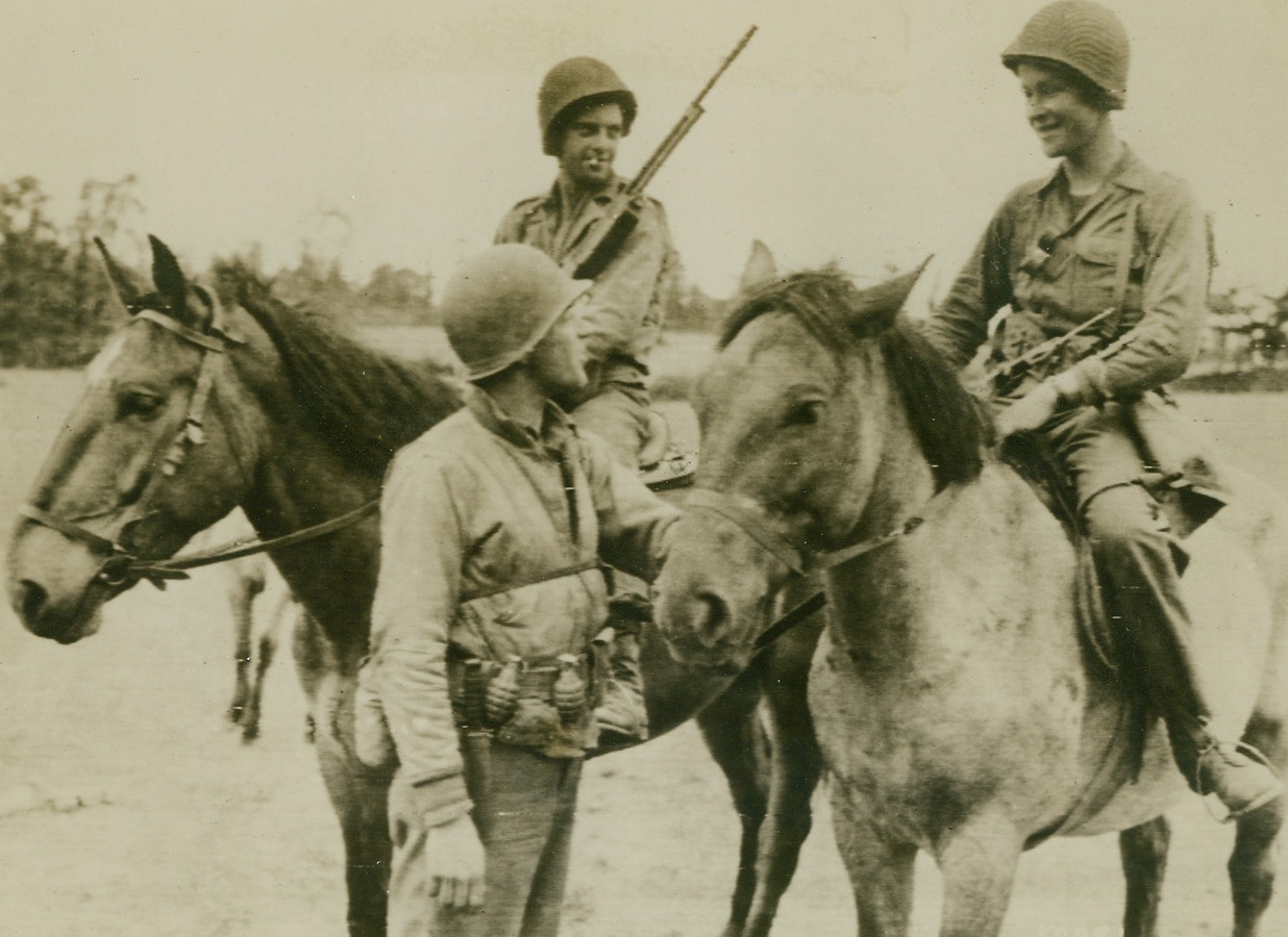 The Rangers Bring ‘Em In!, 6/13/1944. France - These two Mounted Rangers were sent out to forage for food all along the Allied beachhead in France - they returned with 43 German prisoners. Here, they talk things over with their commander. These American equivalents of the British Commandos, were in the forefront of the Allied landings. Note knife and grenades handing from the Commander’s belt. Credit: ACME photo via Army Radiotelephoto;