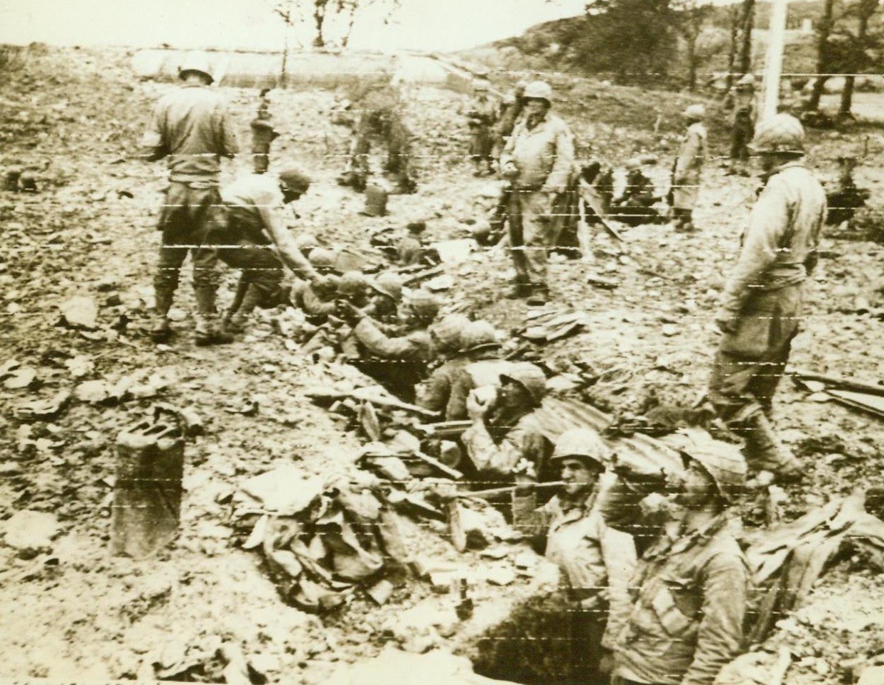 Wet Leatherneck, 6/28/1944. Saipan- This wet Leatherneck took a ducking when the landing craft in which he came was hit by Jap mortar fire before it reached Saipan beach. Here, he and other Marines, under enemy fire, crawl to their assigned positions. 6/28/44 ACME;