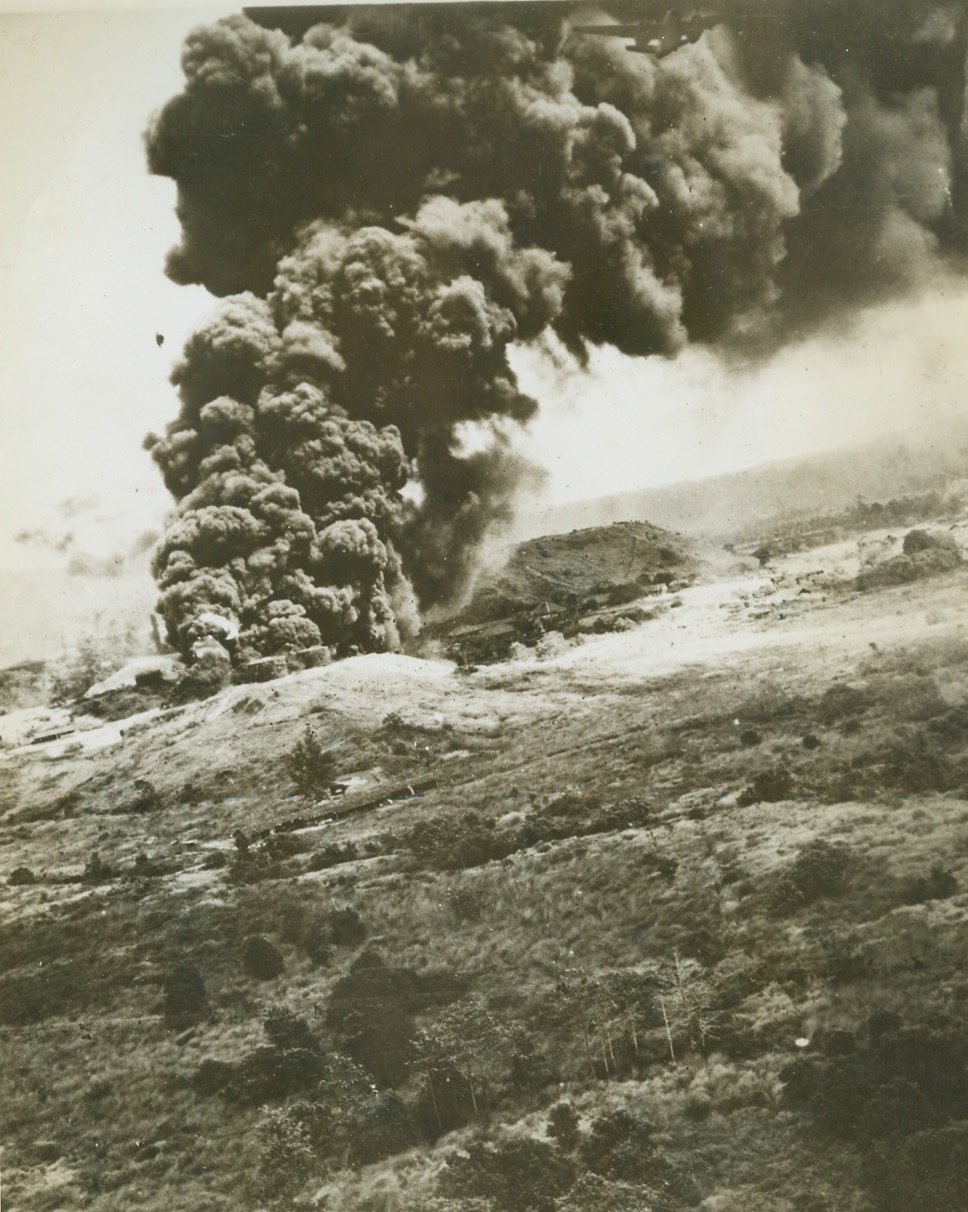 IT’S GOING TO BE COLD THIS WINTER, 7/29/1944. DUTCH EAST INDIES- Columns of black smoke rise in the air after Japanese oil supply dumps at Boela, Ceram Isal, Dutch East Indies, received direct hits from Lt. Gen. Kenny’s 5th Air Forces Bombers. One of the bombers can be seen emerging from the smoke (top center). Credit: USAAF photo via OWI Radiophoto from ACME;