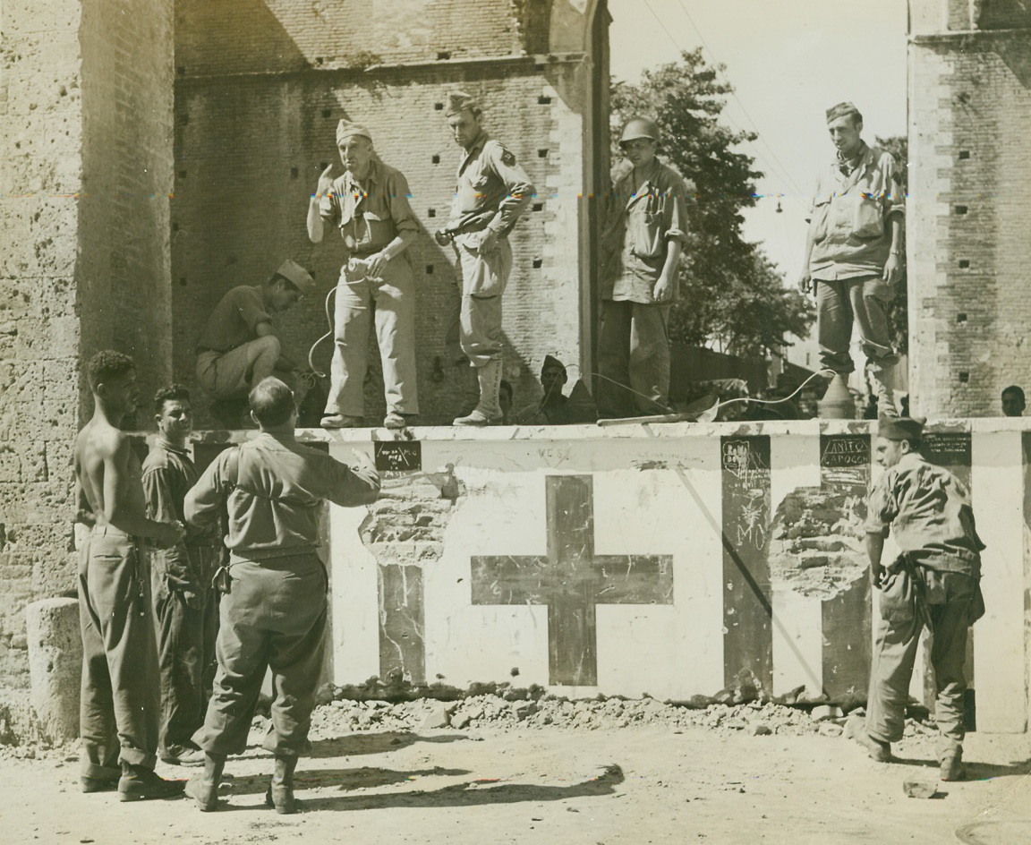 FRENCH CLEAR ROAD FOR ALLIED ADVANCE—#1, 7/9/1944. ITALY—When French troops of the Allied Fifth Army entered and captured Siena in Italy, they found this German road block in the middle of the town obstructing their rapid advance after the fleeing Nazis. Demolition squads got to work on the road block and blasted a path for the rolling, triumphant Allied forces. Here French demolition workers prepare the road block for blasting. Credit: Acme photo by Charles Seawood, War Pool Correspondent;