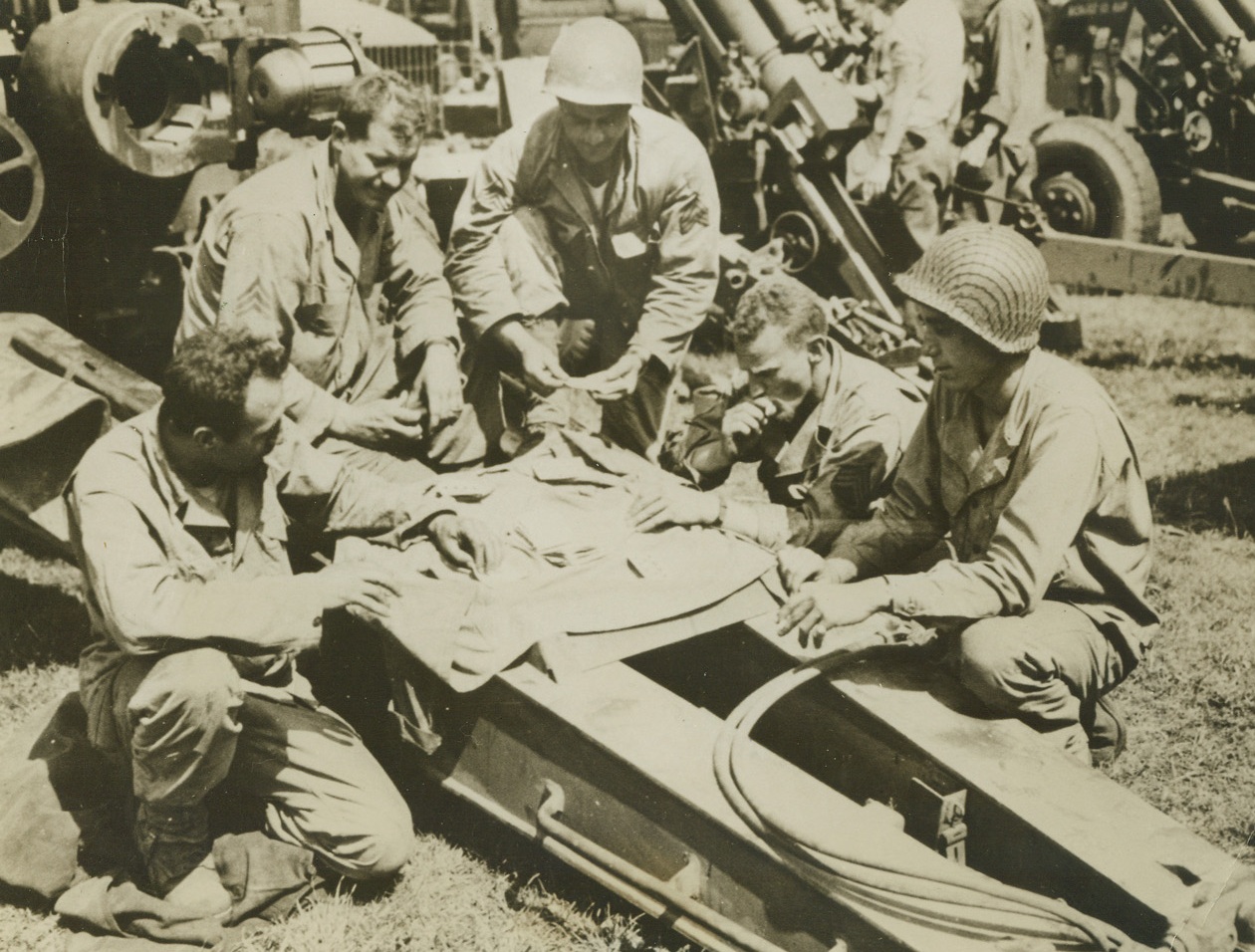 PROTECTION AND POKER, 7/29/1944. FRANCE—In an off-duty moment at a base in Normandy, card players take extra special precautions against Nazi kibitzers. Intent on their cards are (left to right): Sgt. Louis Rossi, Brooklyn, N.Y.; Sgt. Joseph Grillo, Brooklyn, N.Y.; S/Sgt. Edward Kamalsi, Detroit, Mich.; and Sgt. Edward Bearden of Waco, Tex. Credit Line (ACME);