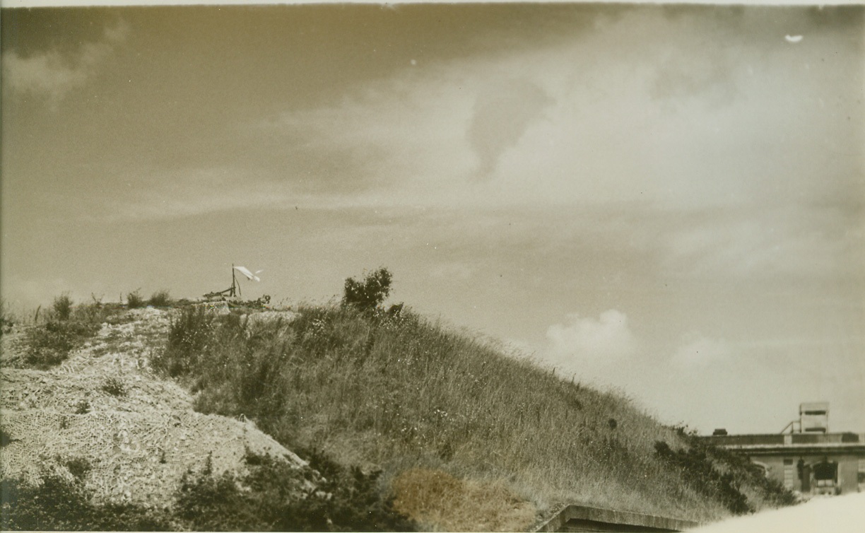 Nazis Surrender Last Cherbourg Fort, 7/8/1944. France—The white flag of surrender waves gracefully in the off-channel breeze as it goes up over a Nazi fortress in Cherbourg. This last pocket of enemy resistance went to the Allied troops only after putting up a terrific battle (passed by censor).  Credit: ACME photo by Bert Brandt, war pool correspondent;