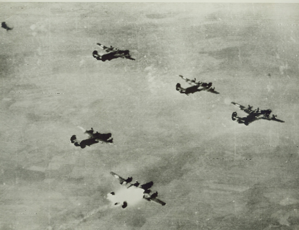 A Liberator is Lost, 8/8/1944. A B-24 Liberator of the U.S. 15th Air Force bursts into flames after it was hit by enemy fire during a raid on the North Oil refinery at Blechhammer, Germany. Three crew members were seen to escape by parachute before the plane disintegrated in midair. Credit Line (Army Radiotelephoto from ACME);