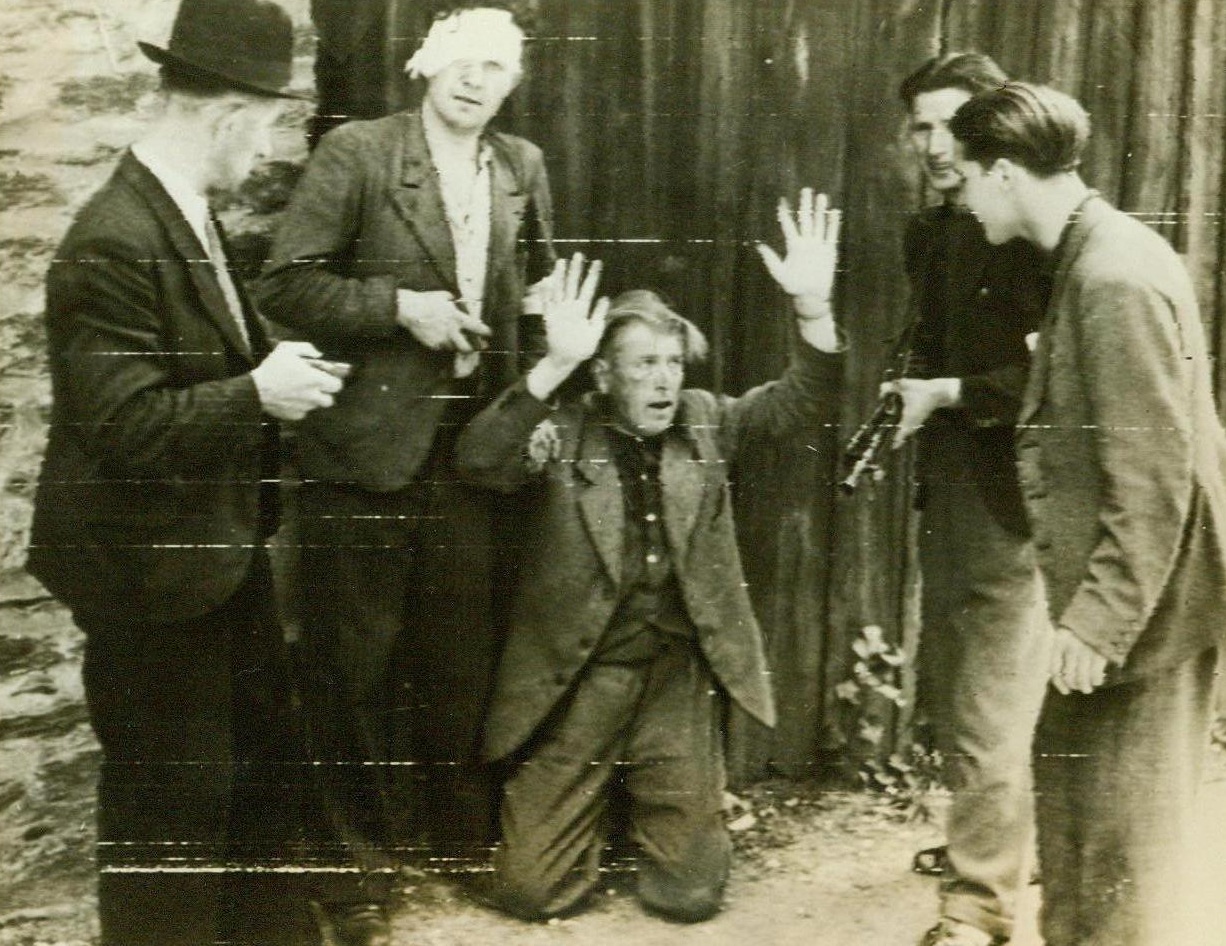 Collaborators Punishment, 8/6/1944. Rennes, France -- In partial payment for his crime of collaborating with the Nazis who dominated Rennes, this traitor is forced to kneel and shout the praises of De Gaulle and Churchill. He looks fearfully at patriots who rounded up disloyal Frenchmen as soon as the capital of Brittany fell to the Allies. 8/6/44 (ACME);