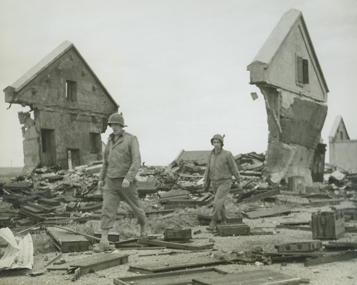 Destroyed German Ammunition Dump, 9/16/1944. American soldiers walk through the wreckage of packing cases and masonry which are all that is left of a German ammunition dump near Metz, destroyed by the enemy as he retreated into Germany. Credit: ACME PHOTO BY BERT BRANDT FOR THE WAR PICTURE POOL.;