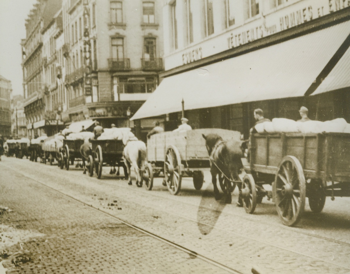 Jerry Beats It – With the Goods, 9/22/1944. BRUSSELS, BELGIUM – Leisurely moving out of Brussels, well ahead of advancing Allied troops, Nazi soldiers take carts full of stolen Belgian flour with them. This photo was made secretly by Van Osta, a Belgian cameraman, who risked his life to record the Nazi flight. Credit Line (ACME);