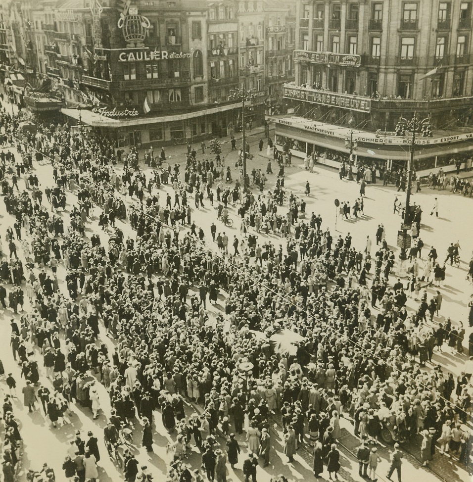 BRITAIN REPORTS TO NEWS-STARVED PEOPLE, 9/9/1944. BRUSSELS, BELGIUM—The Place de la Bource in Brussels is alive with people as a British loudspeaker broadcasts the latest news reports to citizens of the town who have heard no news, save propaganda, since the German occupation. Credit (ACME) (WP);