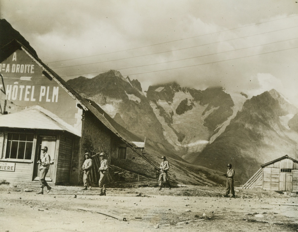 Returning After Skirmish, 9/10/1944. Briancon, France -- With the snow-covered mountains of the Italian Alps rising to meet the clouds in the background, a five-man American patrol wends its way back to American lines after an encounter with the Germans near Briancon, France, which is near the Italian border. Credit: ACME;