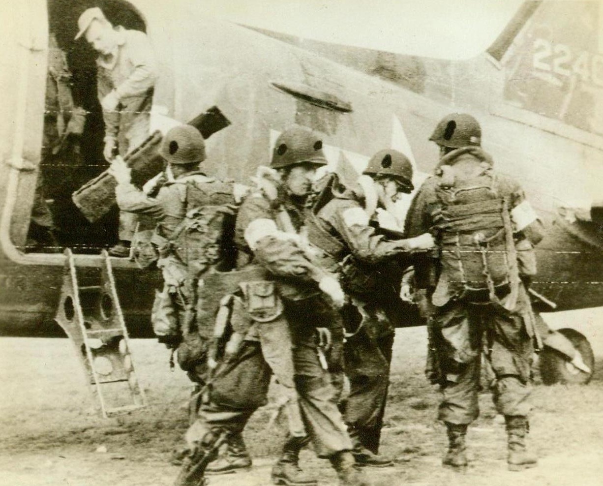 Holland Bound, 9/17/1944. England - Bustling about a giant C-47 Transport, American Airborne Troops prepare to take off on the heavy sky invasion of Holland. The First Allied Airborne Army sent more than 1000 Transports and Gliders to the Netherlands, to settle behind enemy lines and outflank the vaunted Westwall. Credit: Signal Corps Radiotelephoto from ACME;