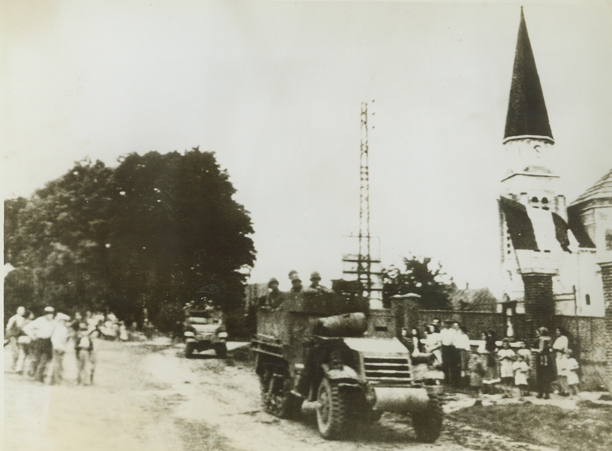 Yanks Reach Former Battleground, 9/4/1944. CANTIGNY, FRANCE -- Yank troops roll through the town of Cantigny, where their fathers fought one of the greatest battles of World War I twenty-six years ago. Civilians come out to cheer the liberators as they roll by.  Credit: (Army Radiotelephoto from ACME);