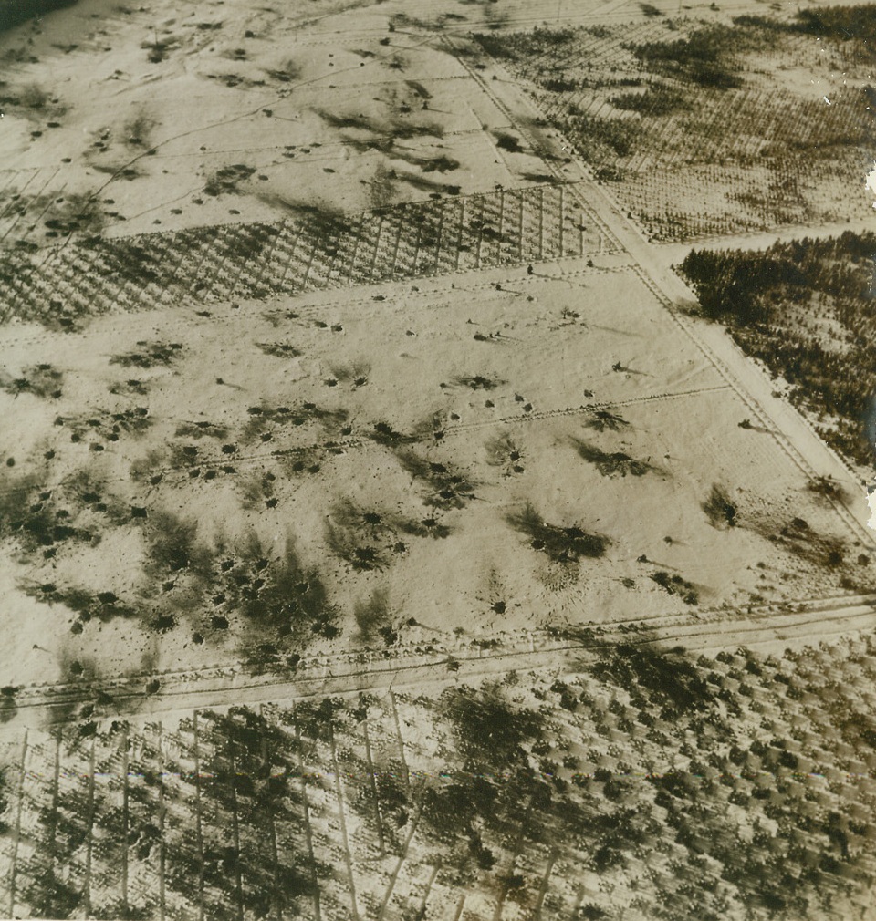 Scene of Battle, 1/27/1945. On the snow-covered terrain of the Ardennes, bomb bursts form crude pock-marked patterns as a result of the Battle of the Bulge near town of Langlir, Belgium. Credit: ACME;