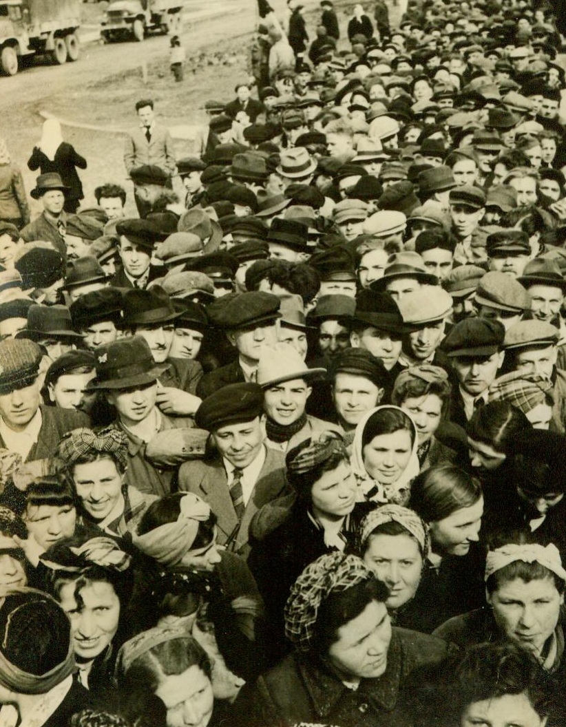 Slaves No More, 3/30/1945. Germany— Civilians, who were imported by the Germans from occupied countries to serve as slave laborers, crowd into the displaced persons center to receive their food rations after their liberation by advancing Allied Armies. In this group are people of all nationalities— Poles, French, Belgians, and Russians, and eventually Allied military authorities will see that they are sent back to their homelands. 3/30/45 Acme;