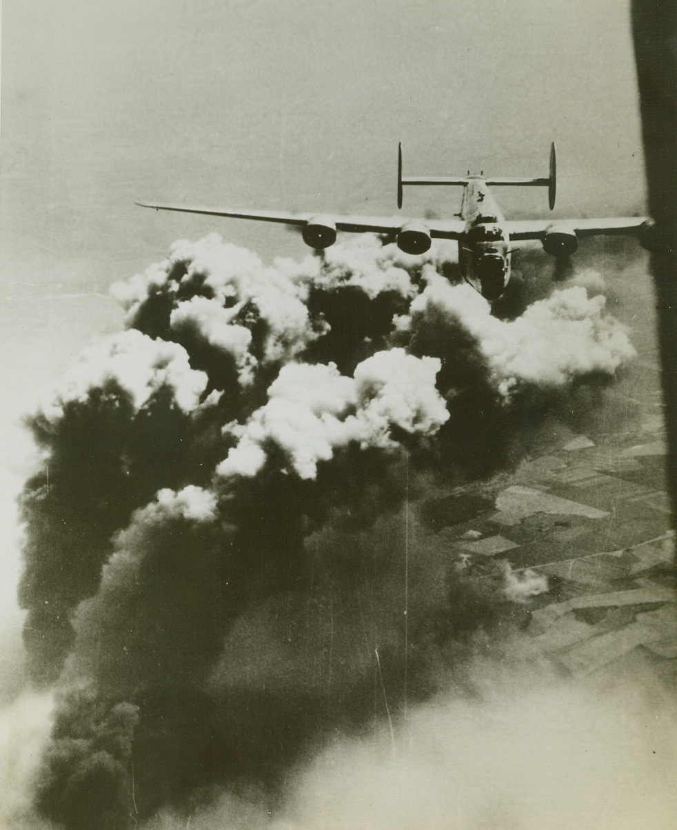 Dark Clouds Hang Over Romania. ROMANIA – Riding above this towering column of smoke is a B-24 Liberator of the U.S. Army 15th Air Force after its bombs started fires in the Astro Romono oil refinery at Ploesti, Romania. This latest attack by heavy bombers was one of the many smashing blows on the rapidly dwindling Nazi oil supplies. (Acme);