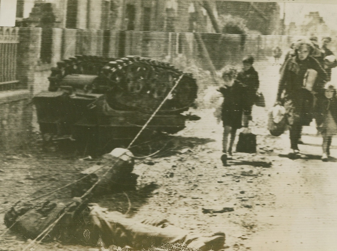 No Title. French civilians returning to Pont L’abbe after the Allied pushed the Germans from the town, pass dead Germans and samashed German Equipment. Acme via Signal Corps radio telephoto.;