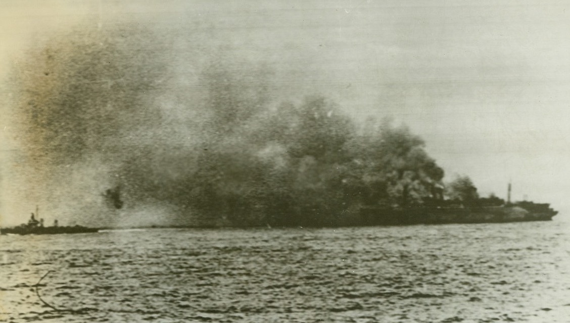 No Title. U.S.S. Wakefield (formerly the Manhattan) afire at sea. Small ship at left is a destroyer. Credit: Official U.S. Navy photo from ACME;