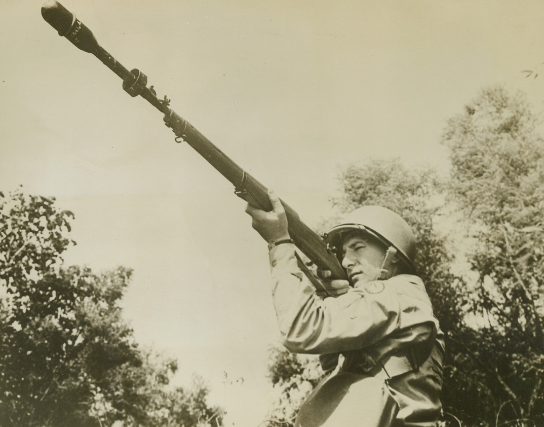 U.S. Army Rifle Grenade. By the addition of this launcher-adaptor, this ordinary U.S. Army 30-calibre rifle may be quickly altered to propel a high powered rifle grenade. Such a weapon can be used with telling effect against enemy pill boxes and gun emplacements and covers the interval between the distance a soldier can toss a grenade and the much greater range of the mortar or the now famous Bazooka. Here, a soldier sights a rifle equipped for firing rifle grenades. Credit: U.S. Army photo from ACME;