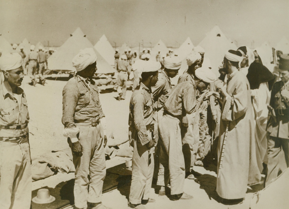 Free Libyans and Leader, 12/5/1940  Egypt – Members of the Senussi – a high religious order – who escaped from Libya, kiss the hand of their leader, Sayed Idris, after arrival in Egypt, where they will join the fight to overthrow Italian control of Libya. Credit line (ACME);