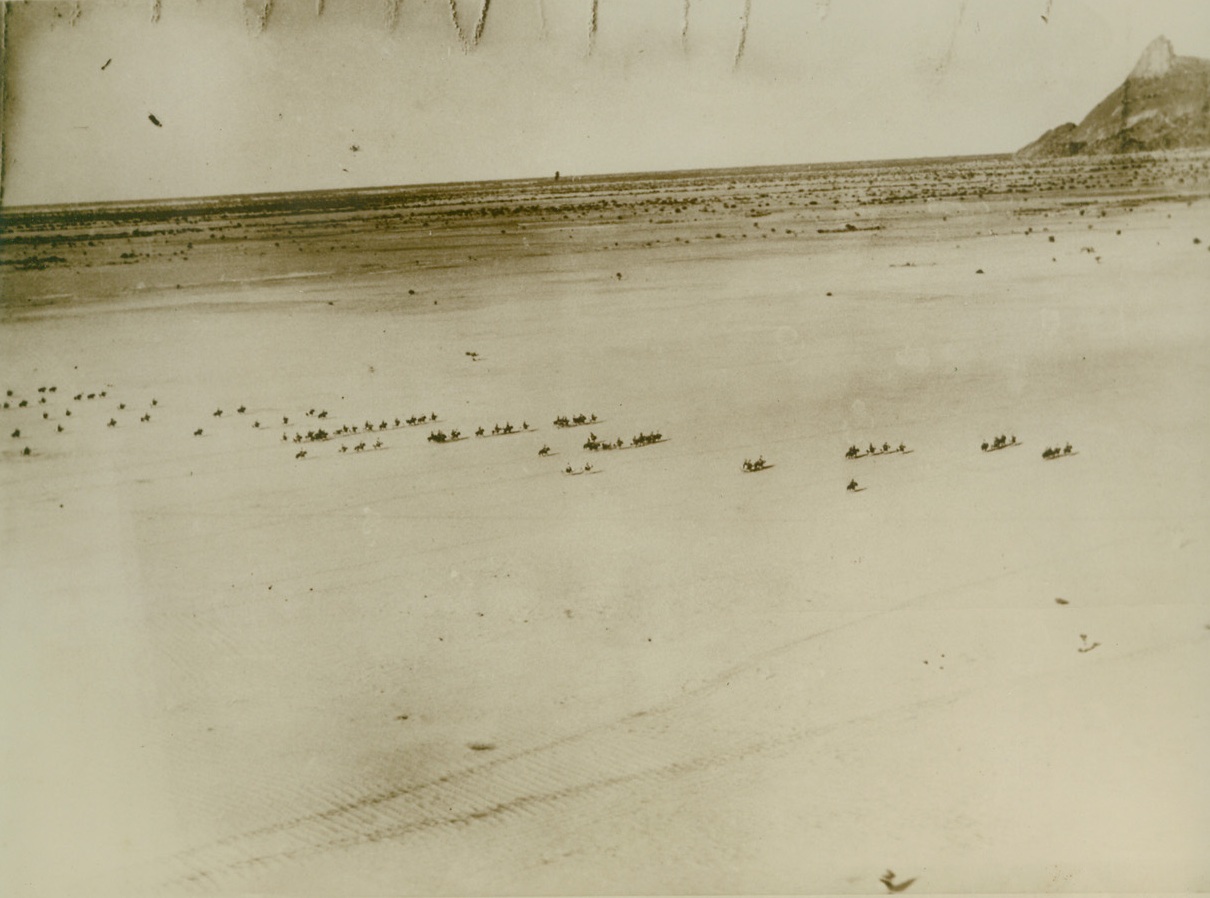 Italy Strengthens Ethiopian Defenses, 12/31/1940  ETHIOPIA – Apprehensive of a British attack in Eastern Africa since loss of territory in Egypt and Libya, Italy is rushing new forces to supplement her defenses in Ethiopia. Here according to Italian-censored caption, cavalry units in the region of Kassala (Anglo-Egyptian Sudan) advance across the desert, guarded overhead to war planes. In the sand may be seen track of motorized units preceding them. Credit: (ACME);