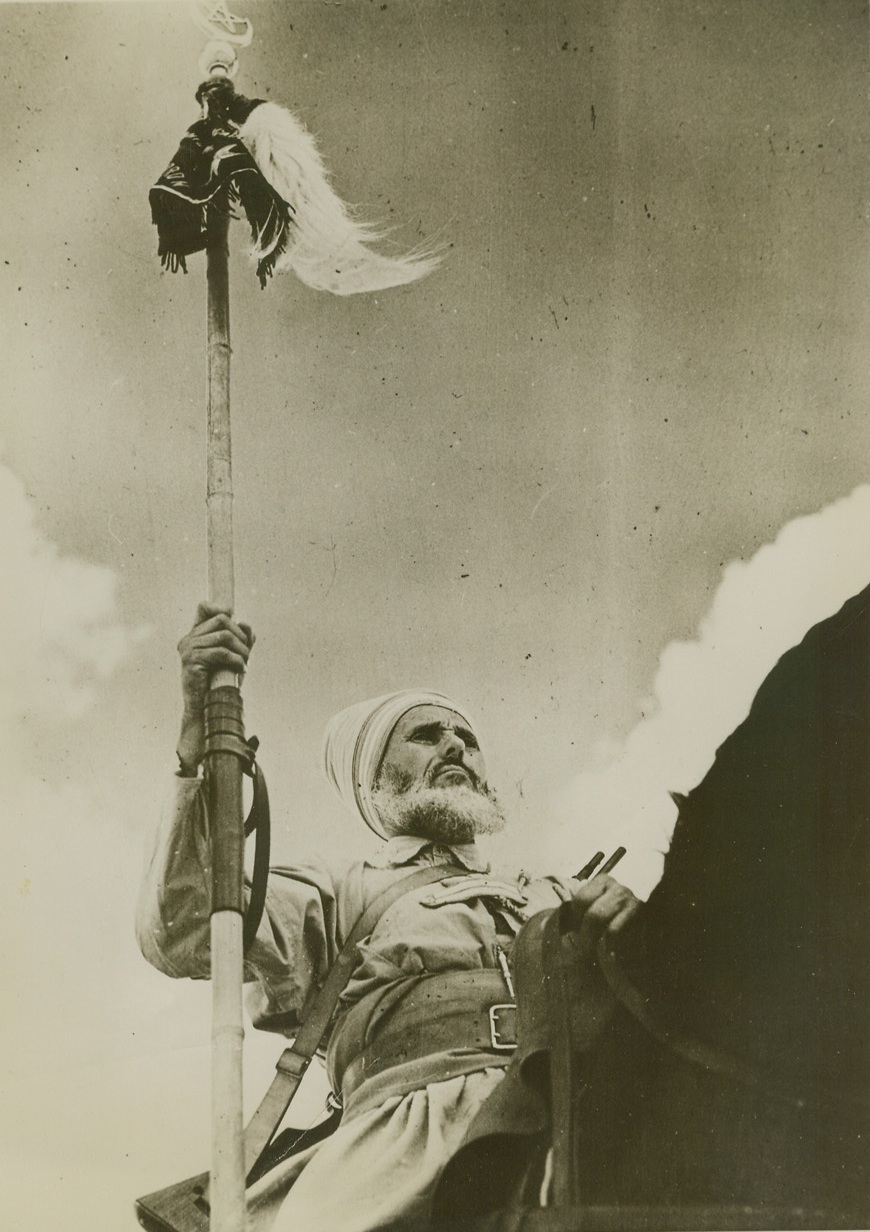 FREEDOM – HIS BREATH OF LIFE, 1/14/41  NORTH AFRICA – As a Sergeant proudly carries the honored pennant of his troops, Spahis, famous desert-bred cavalry of France, maintain an unceasing patrol in the desert with the forces of Free France under General De Gaulle. After the collapse of France, the Spahis rode from Syria to join De Gaulle’s men. Credit: OWI Radiophoto from ACME;