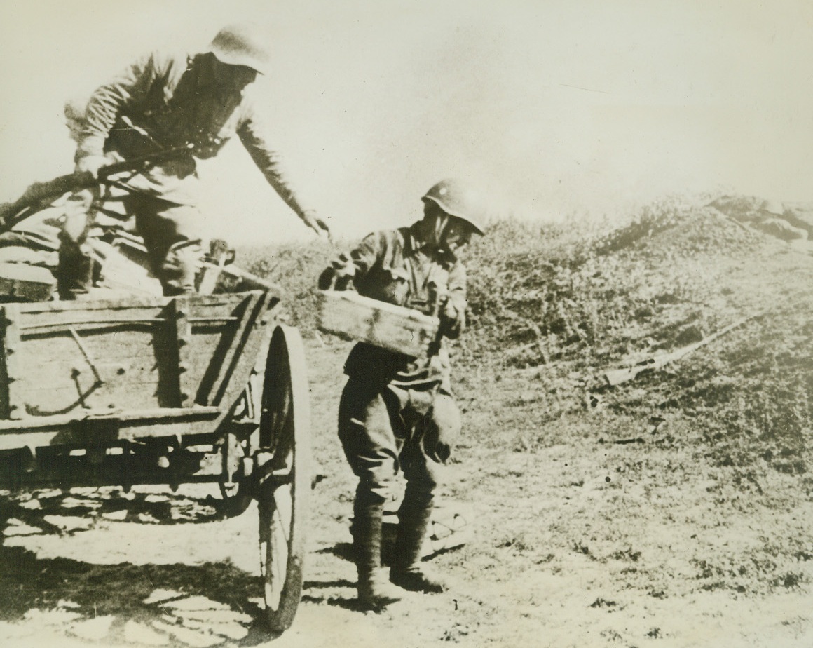 Ammunition for the Soviet Front, 10/24/41  RUSSIA—Even peasant carts are requisitioned if no lorries are immediately available, so that Soviet infantry in the firing line can get ammunition they need. Here are two Red Army soldiers delivering rifle ammunition and grenades to a forward position. Note the well-protected, camouflaged firing post beside the rough road. Passed by British censor. Credit: ACME;